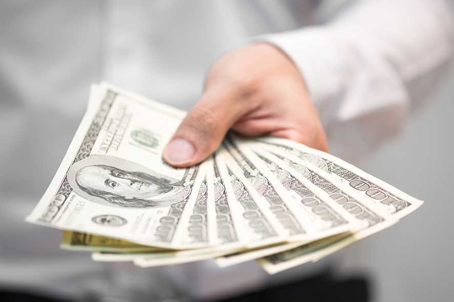 Businessman holding money on hand, Spreading one hundred US Dollar bills.